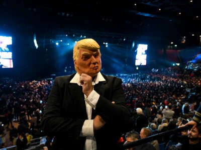 A supporter of Argentinian President Javier Milei wears a mask of former U.S. President Donald Trump during a promotional event for a new book by the Argentinian head of state.