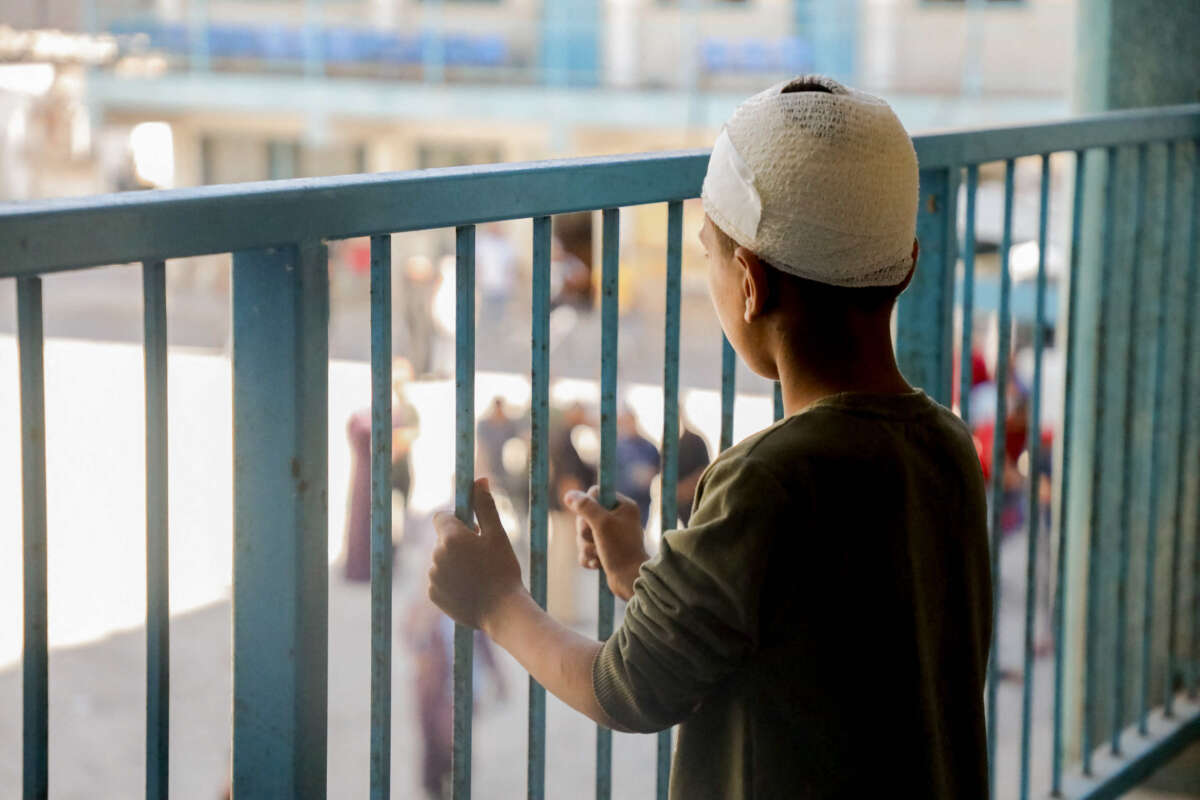 A boy stands by the railing inside a UN school-turned-refuge in the Al-Shati refugee camp near Gaza City, following a reported Israeli strike on October 19, 2024.