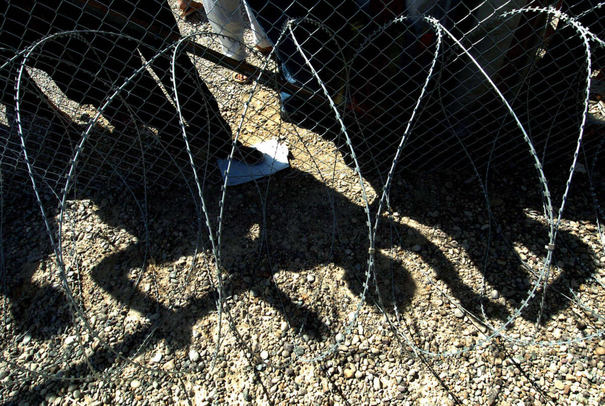 The shadows of Iraqi detainees cast on the ground as they watch the release of prisoners leaving the Abu Ghraib jail on the outskirts of Baghdad on September 16, 2004.