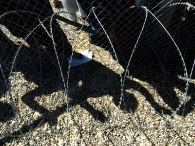 The shadows of Iraqi detainees cast on the ground as they watch the release of prisoners leaving the Abu Ghraib jail on the outskirts of Baghdad on September 16, 2004.