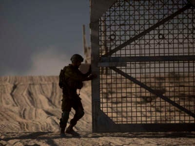 An Israeli soldier closes the border fence leading to the Gaza Strip on November 11, 2024, in Erez West Crossing, Israel.