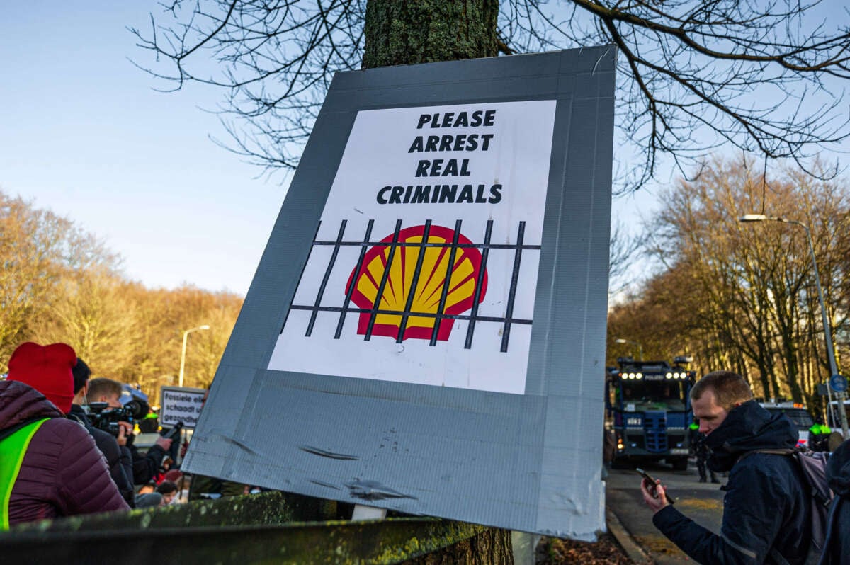 A large poster with the inscription PLEASE ARRIST REAL CRIMINALS with a direct reference to Shell is seen during a demonstration outside the Hague, Netherlands, on March 11, 2023.