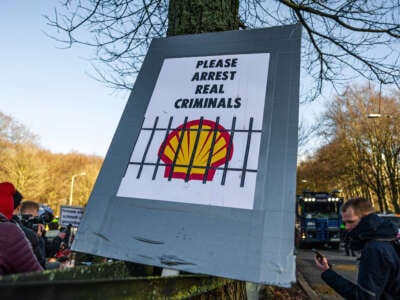 A large poster with the inscription PLEASE ARRIST REAL CRIMINALS with a direct reference to Shell is seen during a demonstration outside the Hague, Netherlands, on March 11, 2023.