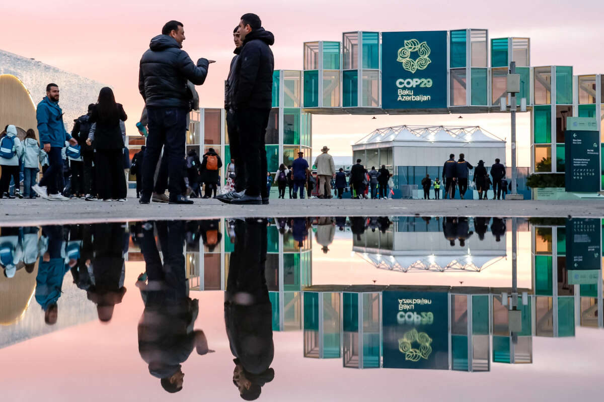 Participants walk and network in front of the main entrance of the United Nations Climate Change Conference (COP29) held at Baku Olympic Stadium in Baku, Azerbaijan, on November 14, 2024.