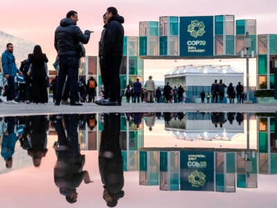 Participants walk and network in front of the main entrance of the United Nations Climate Change Conference (COP29) held at Baku Olympic Stadium in Baku, Azerbaijan, on November 14, 2024.