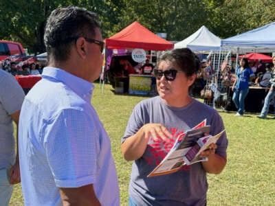 An El Pueblo member campaigning against the constitutional amendment at a community festival in North Carolina, 2024.