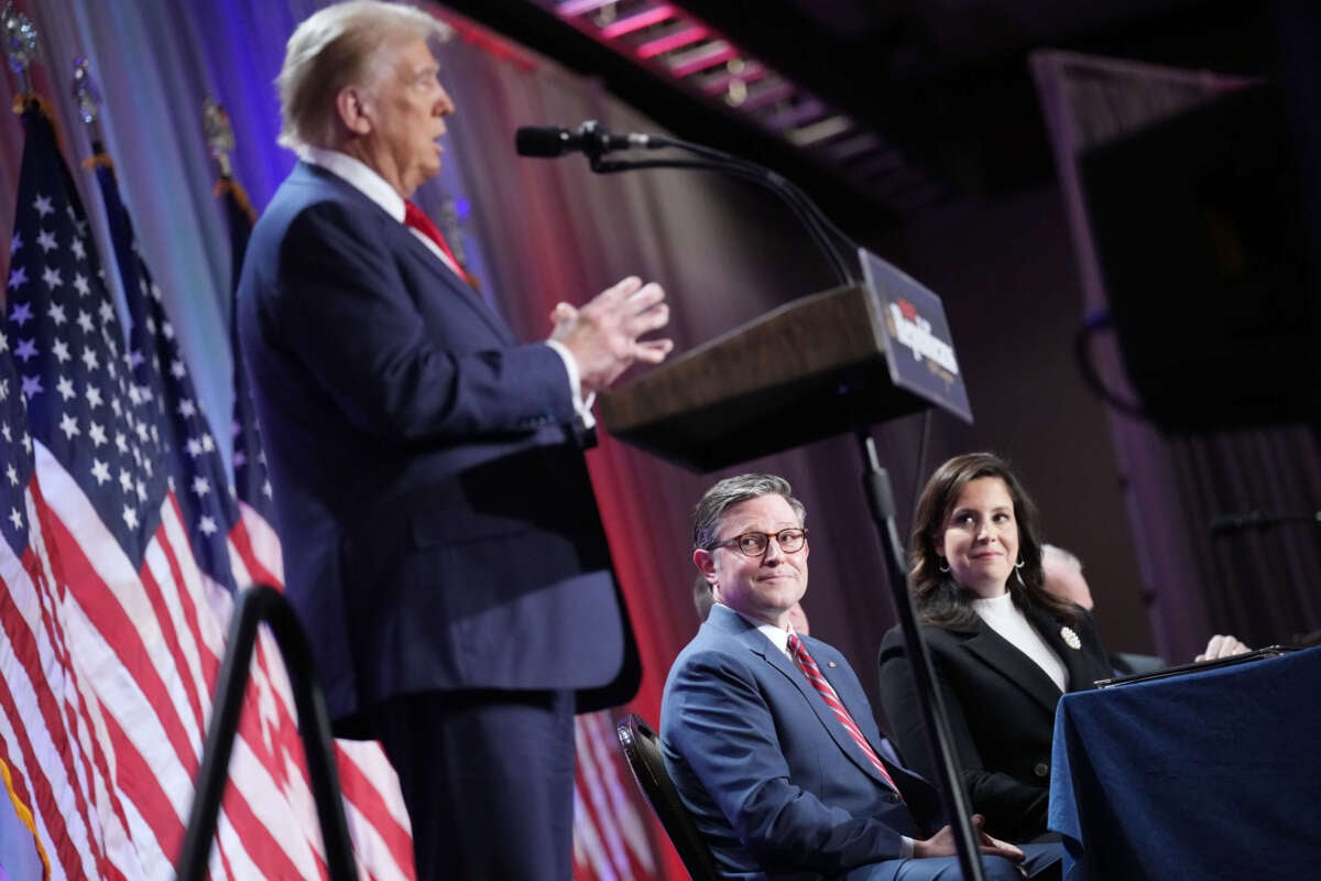 Speaker of the House Mike Johnson (center) and House Republican Conference Chair Rep. Elise Stefanik (right) listen as President-elect Donald Trump speaks at a House Republicans Conference meeting at the Hyatt Regency on Capitol Hill on November 13, 2024, in Washington, D.C.