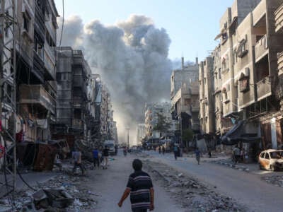 Palestinians rush towards a column of smoke billowing following Israeli bombardment which hit a school complex, including the Hamama and al-Huda schools, in the Sheikh Radwan neighbourhood in the north of Gaza City on August 3, 2024.