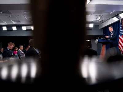 Pentagon Press Secretary Maj. Gen. Pat Ryder speaks to reporters while visually separated by the silhouette of a person's head