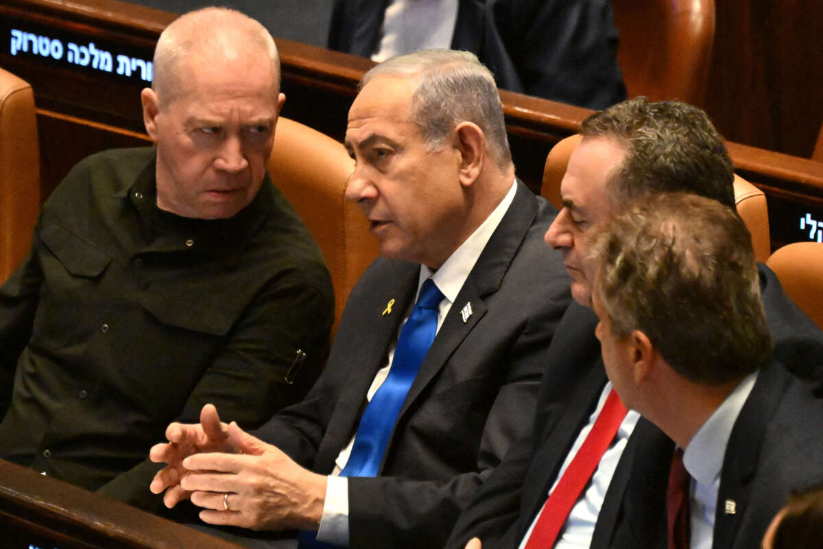 Israeli Prime Minister Benjamin Netanyahu (center) speaks to Defence Minister Yoav Gallant (left) at the opening of the 25th Parliament session in Jerusalem on October 28, 2024.