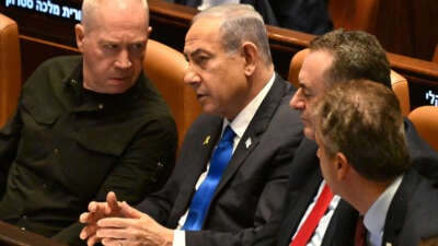 Israeli Prime Minister Benjamin Netanyahu (center) speaks to Defence Minister Yoav Gallant (left) at the opening of the 25th Parliament session in Jerusalem on October 28, 2024.