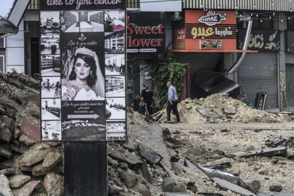 Palestinians walk in the middle of the destroyed commercial market in the city of Jenin in the West Bank, which was demolished by the bulldozers of the Israeli occupation forces, on November 20, 2024.