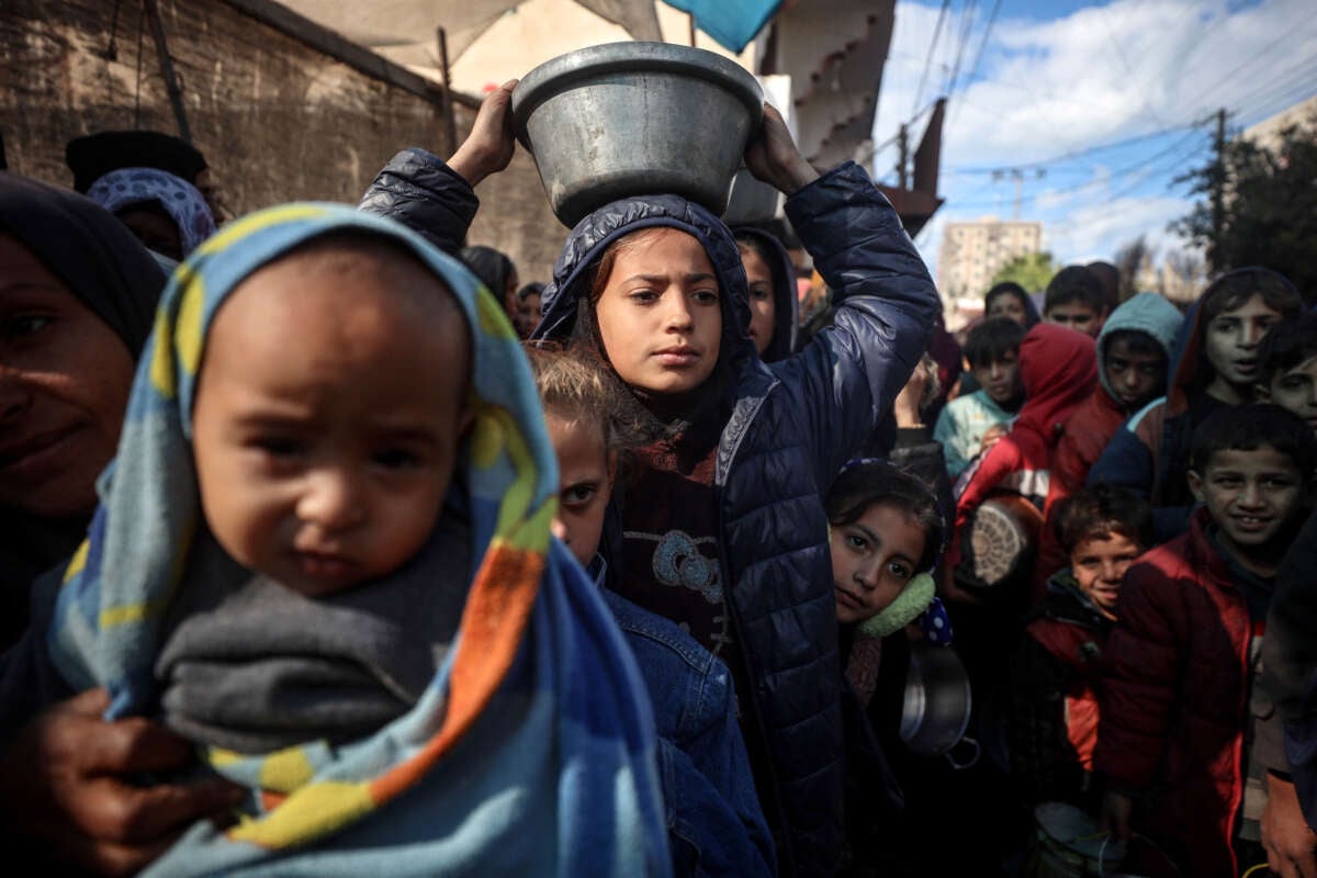 Displaced Palestinian children wait to receive food in Deir el-Balah, central Gaza Strip, on November 26, 2024.