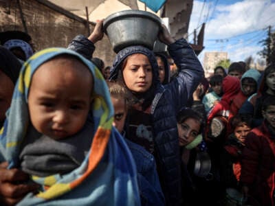 Displaced Palestinian children wait to receive food in Deir el-Balah, central Gaza Strip, on November 26, 2024.