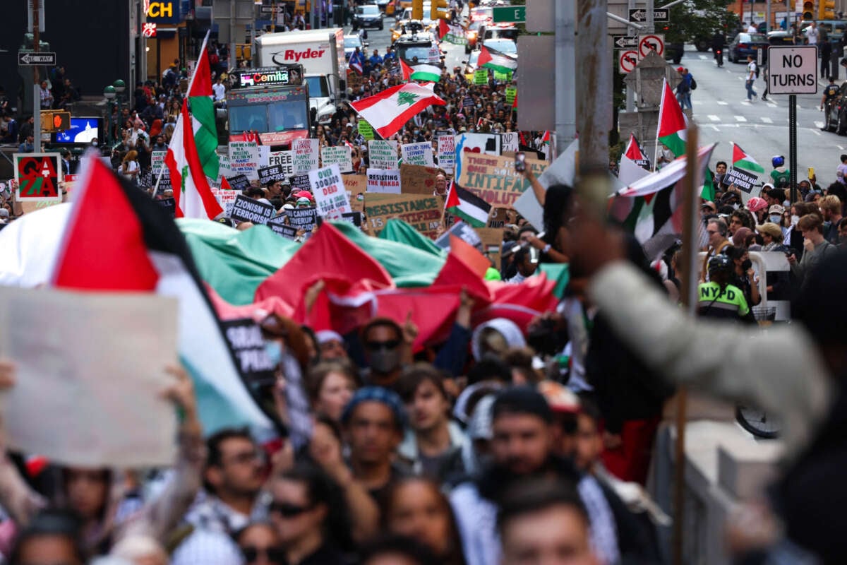 Demonstrators wave flags and hold signs during a pro-Palestine rally in New York City to mark the one-year anniversary of October 7, on October 7, 2024.