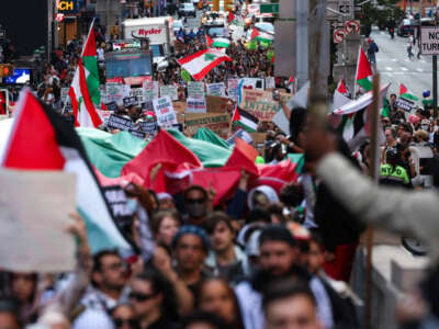 Demonstrators wave flags and hold signs during a pro-Palestine rally in New York City to mark the one-year anniversary of October 7, on October 7, 2024.