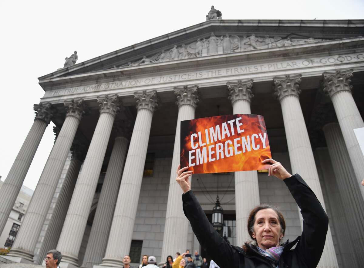 Climate activists gather on the first day of the ExxonMobil trial outside the New York State Supreme Court building on October 22, 2019, in New York City.