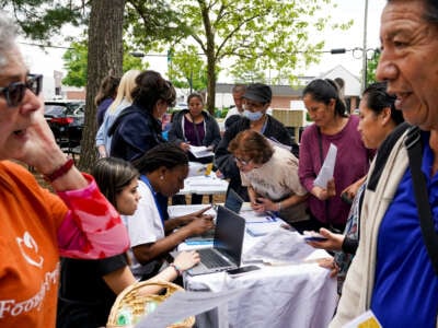 In an event hosted by Second Story, families gather for resources including Medicaid eligibility and enrollment information offered by Neighborhood Health, outside the Springfield/Franconia Family Resources Center on April 27, 2023, in Springfield, Virginia.