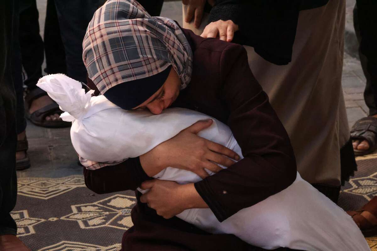 Samia al-Atrash holds the corpse of one of her sister's children from the Khoder family, killed in an Israeli bombardment in Rafah in the southern Gaza Strip, on October 21, 2023.