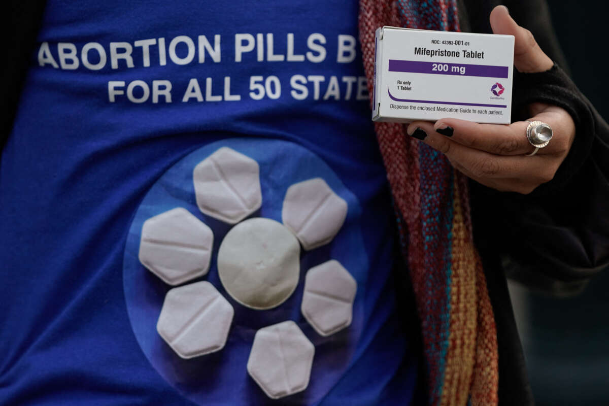 A pro-abortion rights activist holds a box of mifepristone during a rally in front of the U.S. Supreme Court on March 26, 2024, in Washington, D.C.