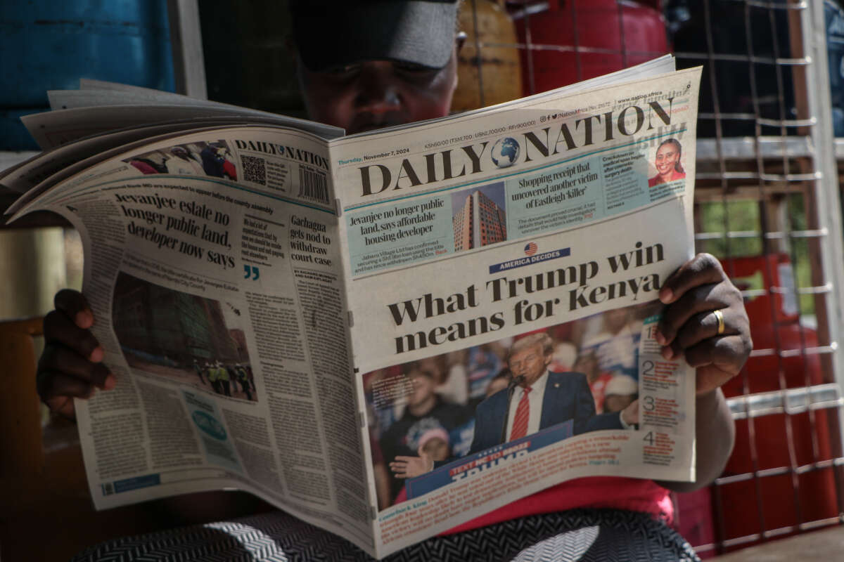 A Kenyan woman reads newspapers at a shop in Nakuru, Kenya, on November 7, 2024, following the U.S. presidential election.