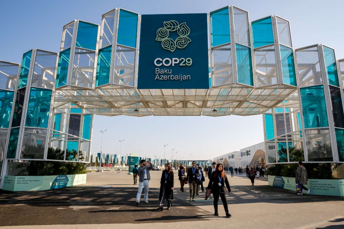 Participants walk by an entrance of COP29 in Baku, Azerbaijan, on November 10, 2024.