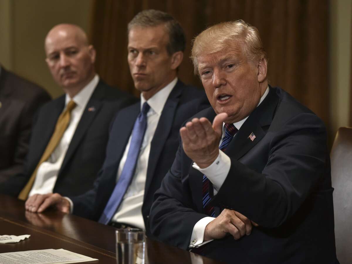 Then-President Donald Trump (right) with Nebraska Gov. Pete Ricketts (left) and South Dakota Republican Sen. John Thune (center) during a meeting on April, 12, 2018, in Washington, D.C.