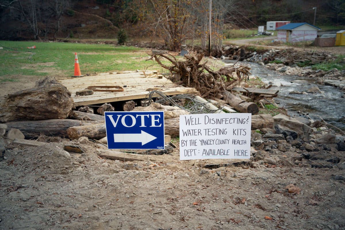 A vote sign is seen beside another sign alerting of well water testing nearby