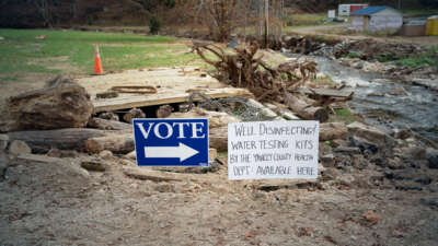 A vote sign is seen beside another sign alerting of well water testing nearby