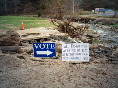 A vote sign is seen beside another sign alerting of well water testing nearby