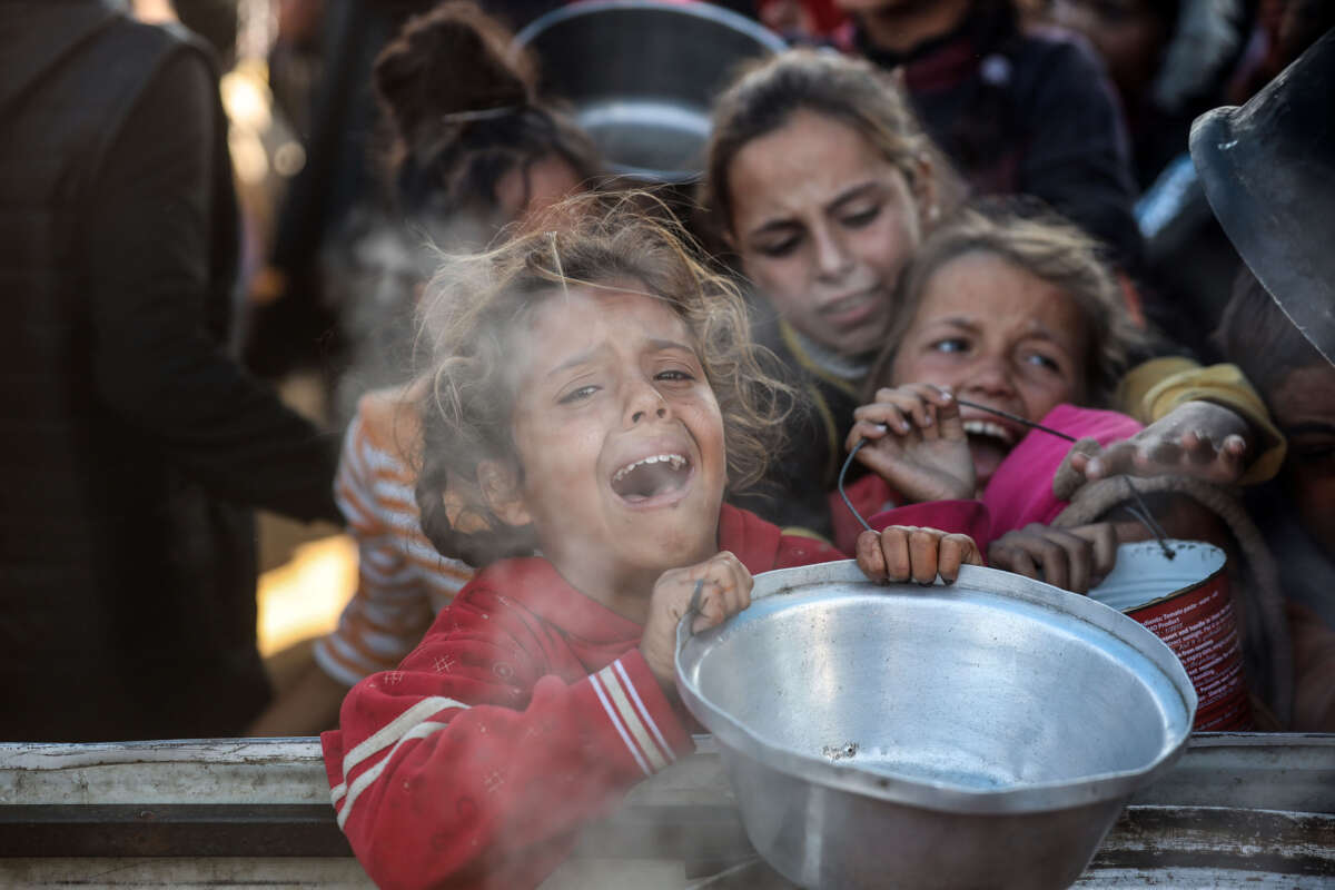 Palestinians gather to receive food cooked by a charity kitchen amid a hunger crisis in Khan Younis, Gaza Strip, on December 1, 2024.