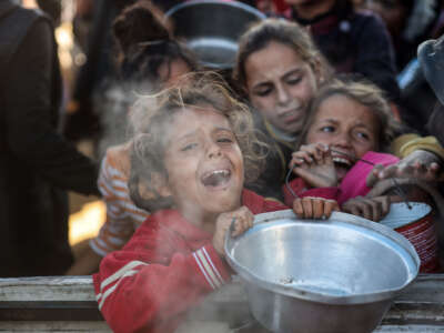 Palestinians gather to receive food cooked by a charity kitchen amid a hunger crisis in Khan Younis, Gaza Strip, on December 1, 2024.