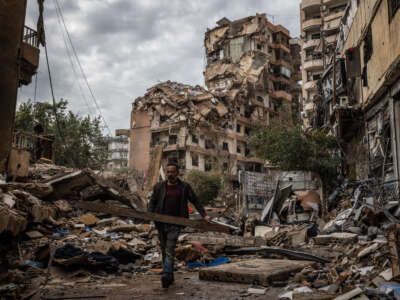 A local man salvages items from the rubble opposite a building destroyed by an Israeli airstrike on a street that goes through the middle of Dahieh on November 29, 2024, in Beirut, Lebanon.