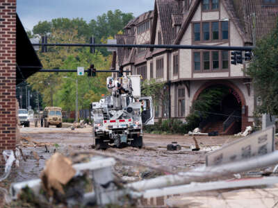 A cherrypicker owned by Duke Energy repairs downed wires in floodwater