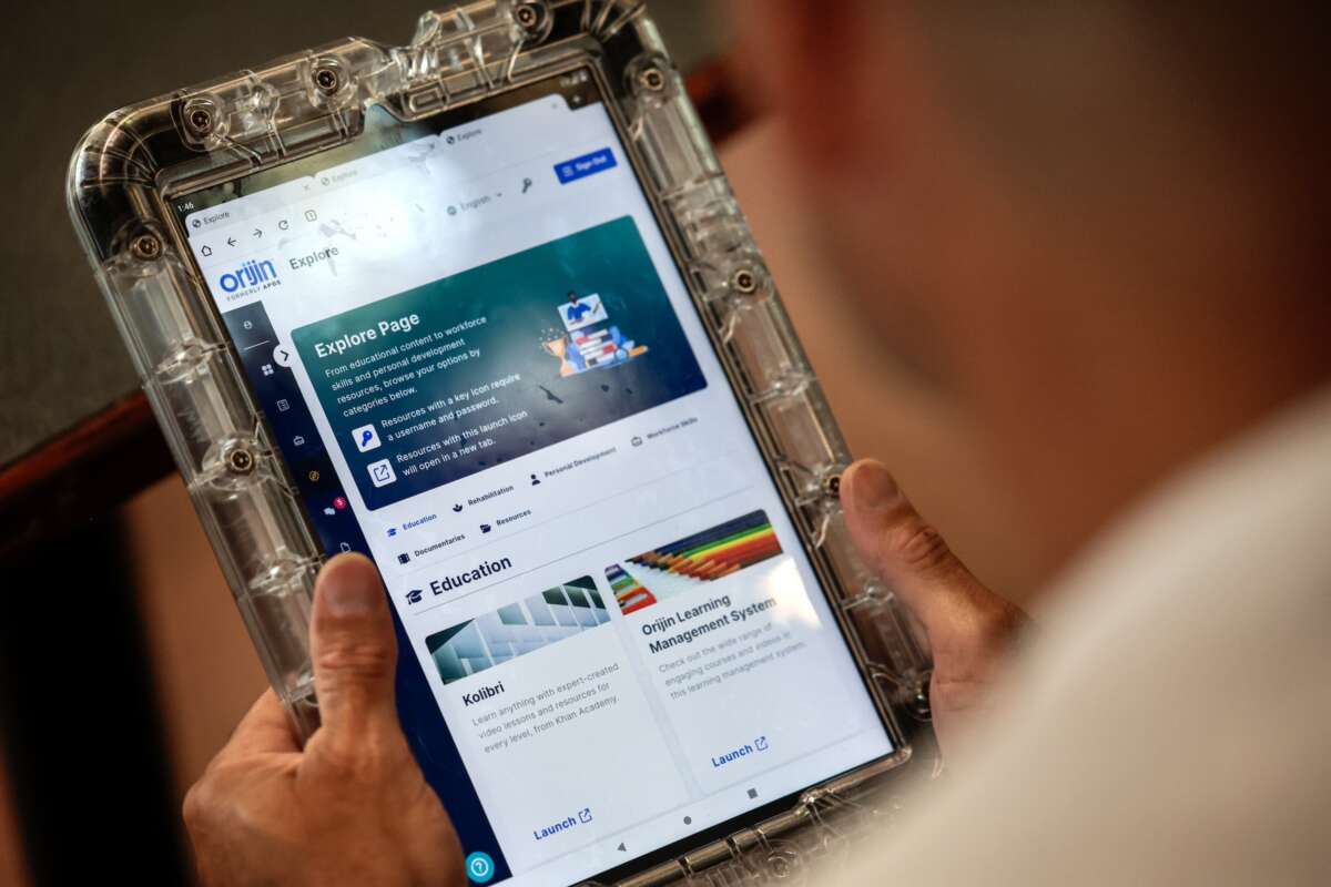 David Class demonstrates the different uses of a program and educational tablet supplied by the Department of Corrections at the Massachusetts Correctional Institution.