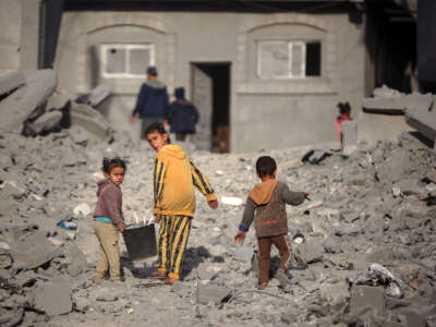 Palestinian children walk among the rubble of a building, destroyed in an Israeli strike, in the Nuseirat refugee Camp in the central Gaza Strip on December 7, 2024.