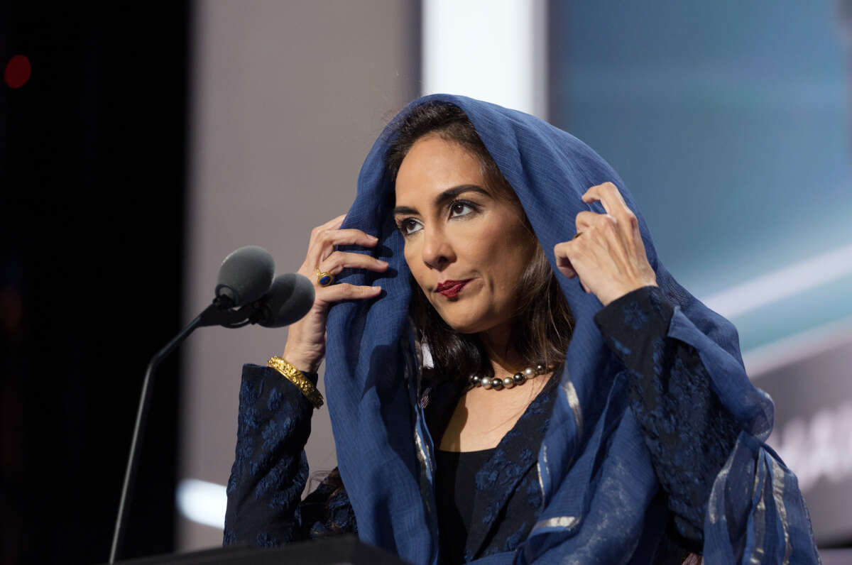 Harmeet Dhillon wears a blue veil while standing at a podium