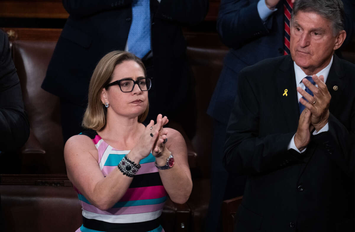 Sens. Kyrsten Sinema and Joe Manchin applaud during the Israeli Prime Minister Benjamin Netanyahu's address to a joint meeting of Congress in the House chamber of the U.S. Capitol on July 24, 2024.