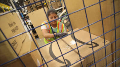 Workers pack and ship customer orders at the 750,000-square foot Amazon fulfillment center on August 1, 2017, in Romeoville, Illinois.