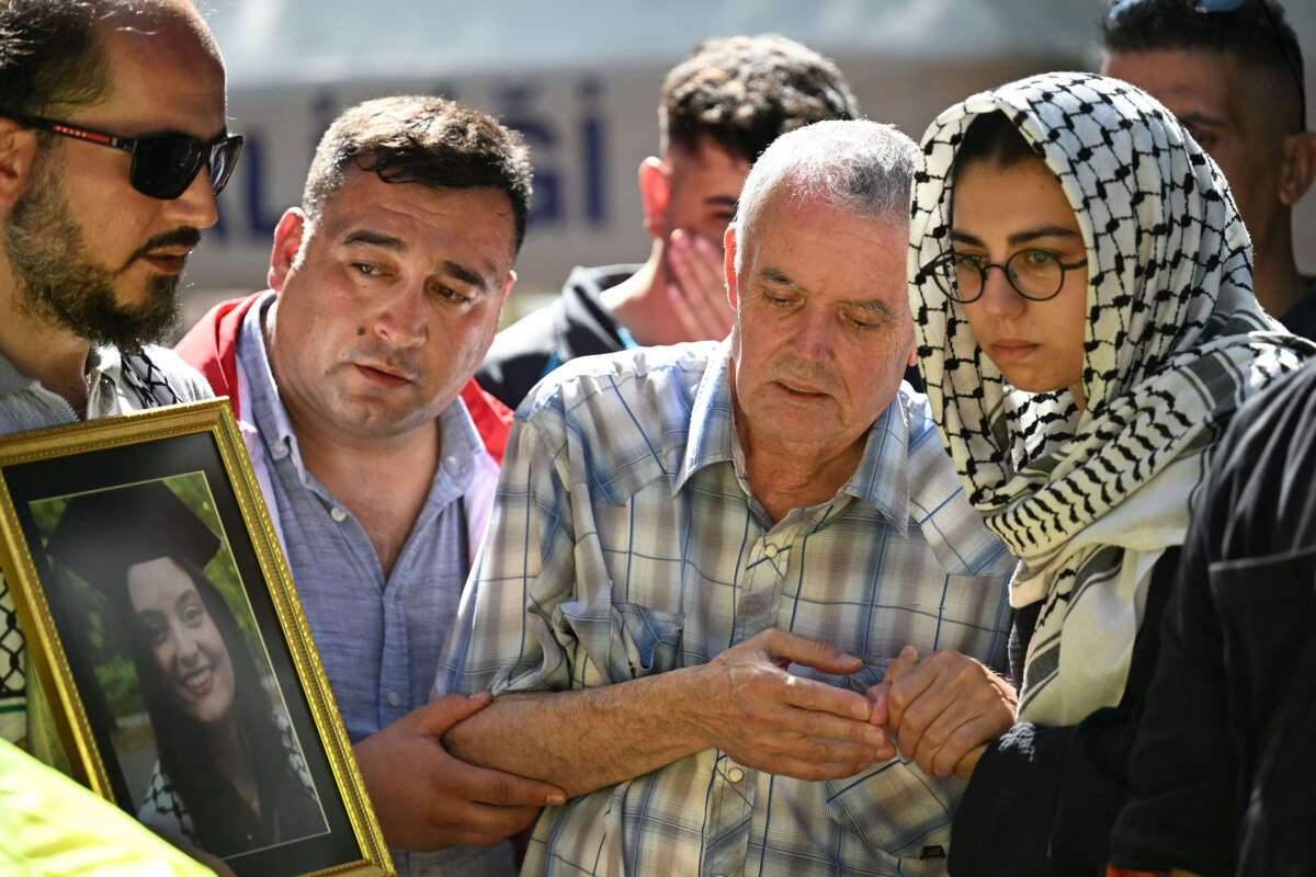 Mehmet Suat Eygi (center), father of late activist Aysenur Ezgi Eygi shot dead by Israeli forces while protesting against illegal Israeli settlements in the occupied West Bank, mourns in front of a portrait of his daughter during her funeral ceremony at the cemetary in Didim, Aydin Province, on September 14, 2024.