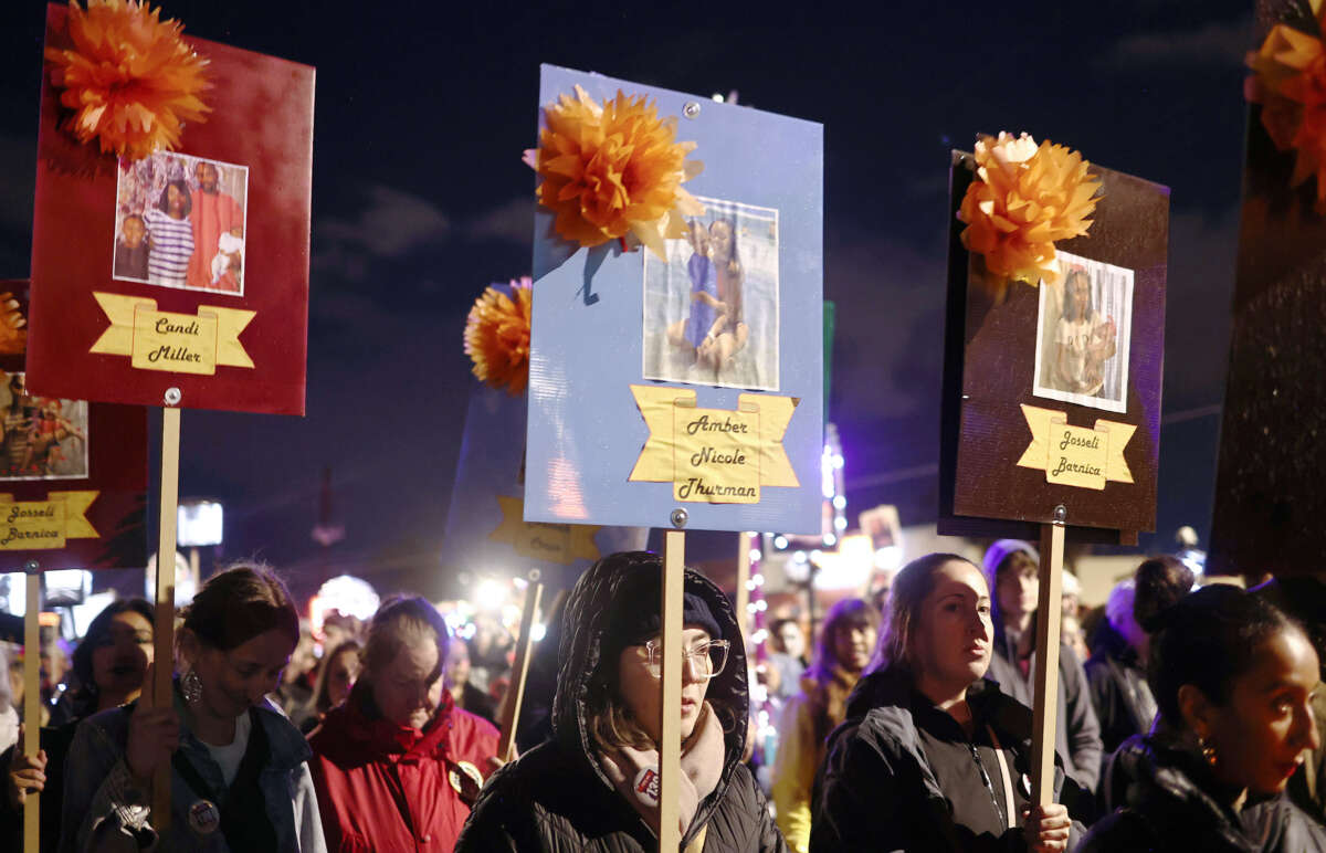 People hold signs with family photographs of Candi Miller, Amber Nicole Thurman, Josseli Barnica, and others who have died as a result of abortion bans