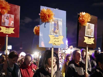 People hold signs with family photographs of Candi Miller, Amber Nicole Thurman, Josseli Barnica, and others who have died as a result of abortion bans