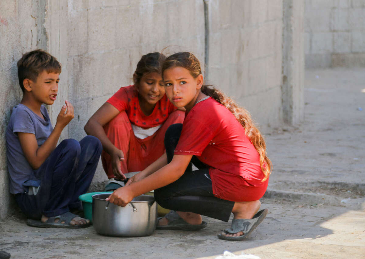 Displaced Palestinian children carry a food ration in Deir al-Balah in the central Gaza Strip on October 17, 2024.