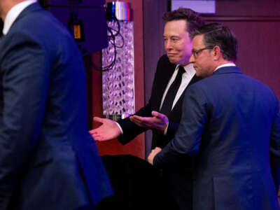 Speaker of the House Mike Johnson (right) tries to help Elon Musk (center) to a seat as he arrives with President-elect Donald Trump to a House Republicans Conference meeting at the Hyatt Regency on Capitol Hill on November 13, 2024, in Washington, D.C.