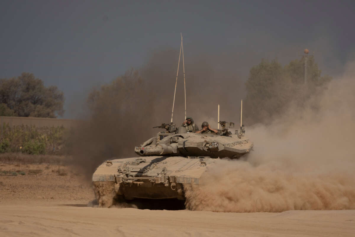 Israeli soldiers stand on a tank as it is moving a long the border with the Gaza Strip on August 29, 2024, in Southern Israel, Israel.