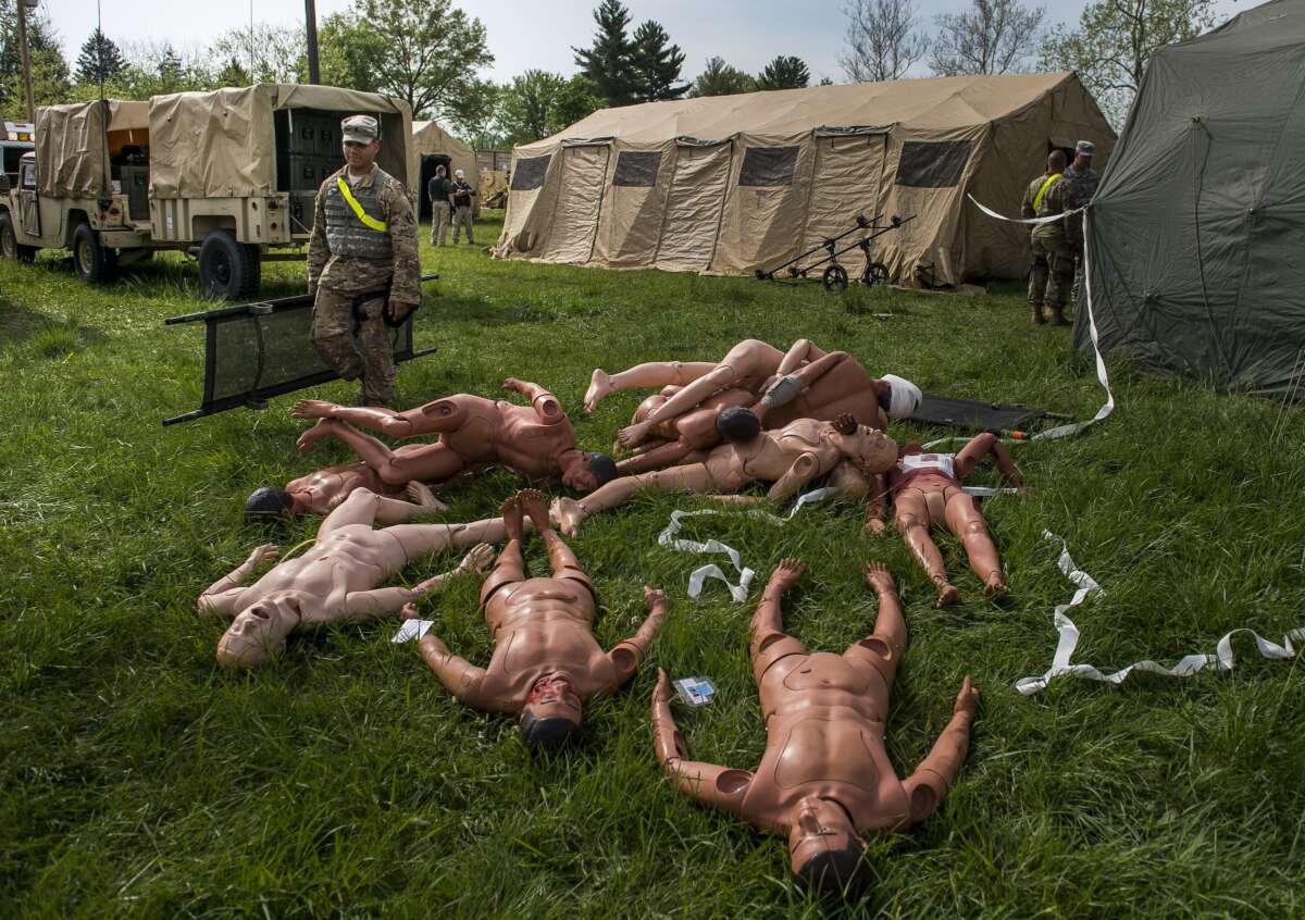 A U.S. Army Soldier carries a stretcher through a decontamination training site at the Muscatatuck Urban Training Center, Indiana.