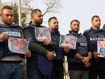 Members of the press stand in solidarity after an Israeli missile hit a media broadcast truck in Nuseirat, on December 26, 2024, outside the Baptist Hospital in Gaza City.