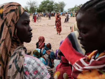 People wait to receive food cards after registering as new arrivals at a camp for internally displaced persons in Agari, South Kordofan, on June 17, 2024.