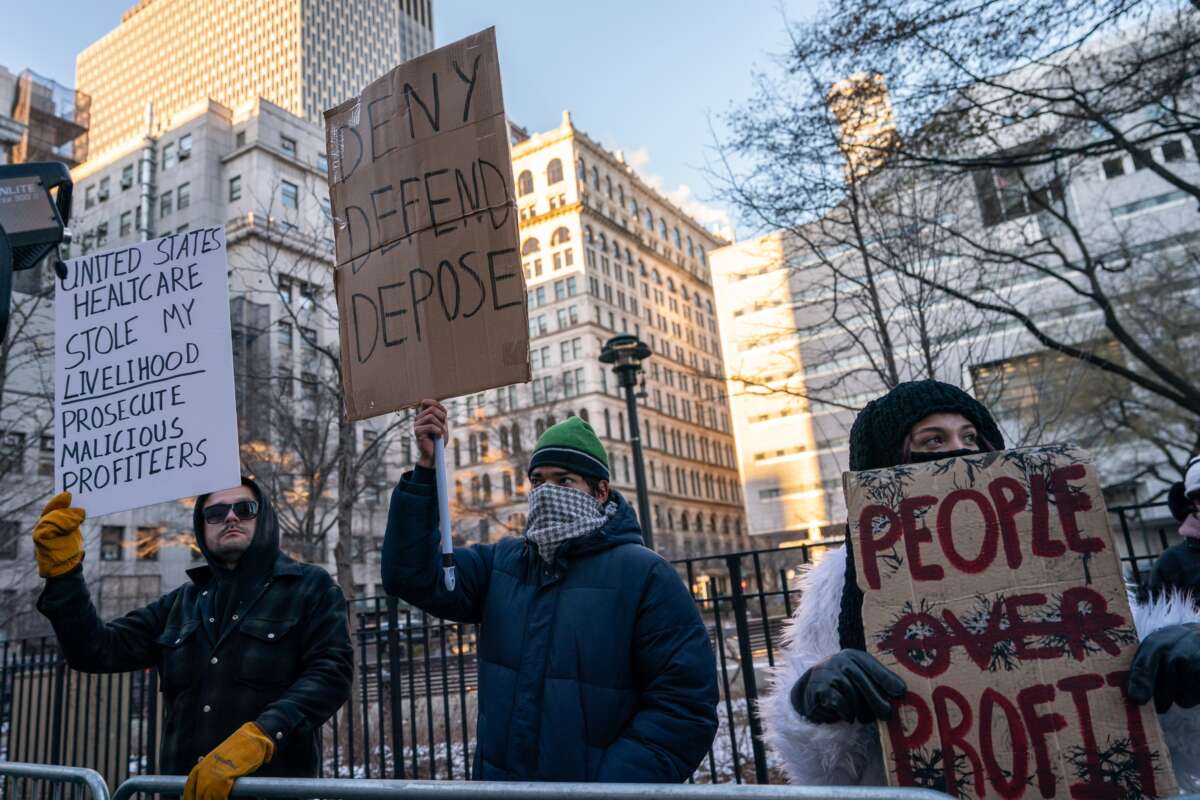 Demonstrators hold signs outside of Manhattan Criminal Court on December 23, 2024, in New York City.