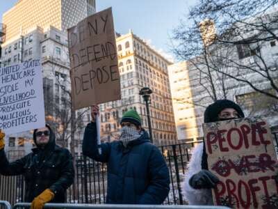 Demonstrators hold signs outside of Manhattan Criminal Court on December 23, 2024, in New York City.